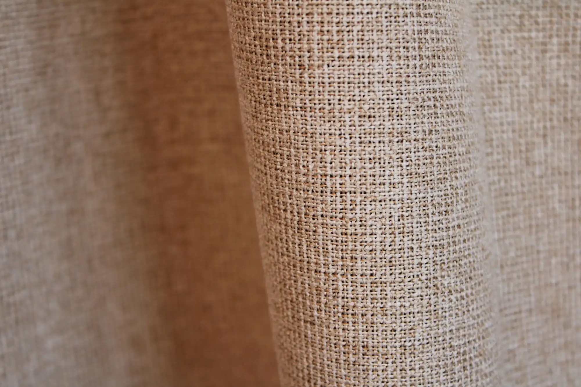 Detail van het stofpatroon van beige verduisterende PureShade gordijnen. De geweven voorzijde geeft de stof een rustige uitstraling.