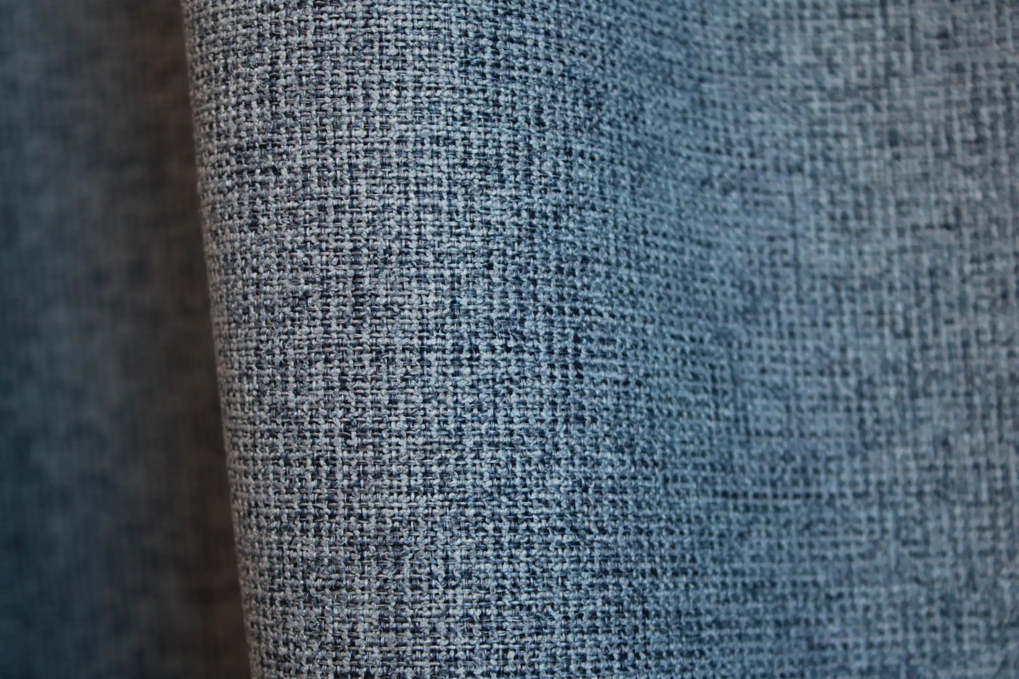 Detail van blauwe verduisterende PureShade gordijnen met zicht op de geweven voorzijde en de meekleurende verduisterende achterkant.