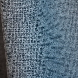 Detail van het stofpatroon van blauwe verduisterende PureShade gordijnen. De licht gemêleerde weving aan de voorzijde geeft de stof extra diepte, met een verduisterende achterkant in dezelfde blauwtint.