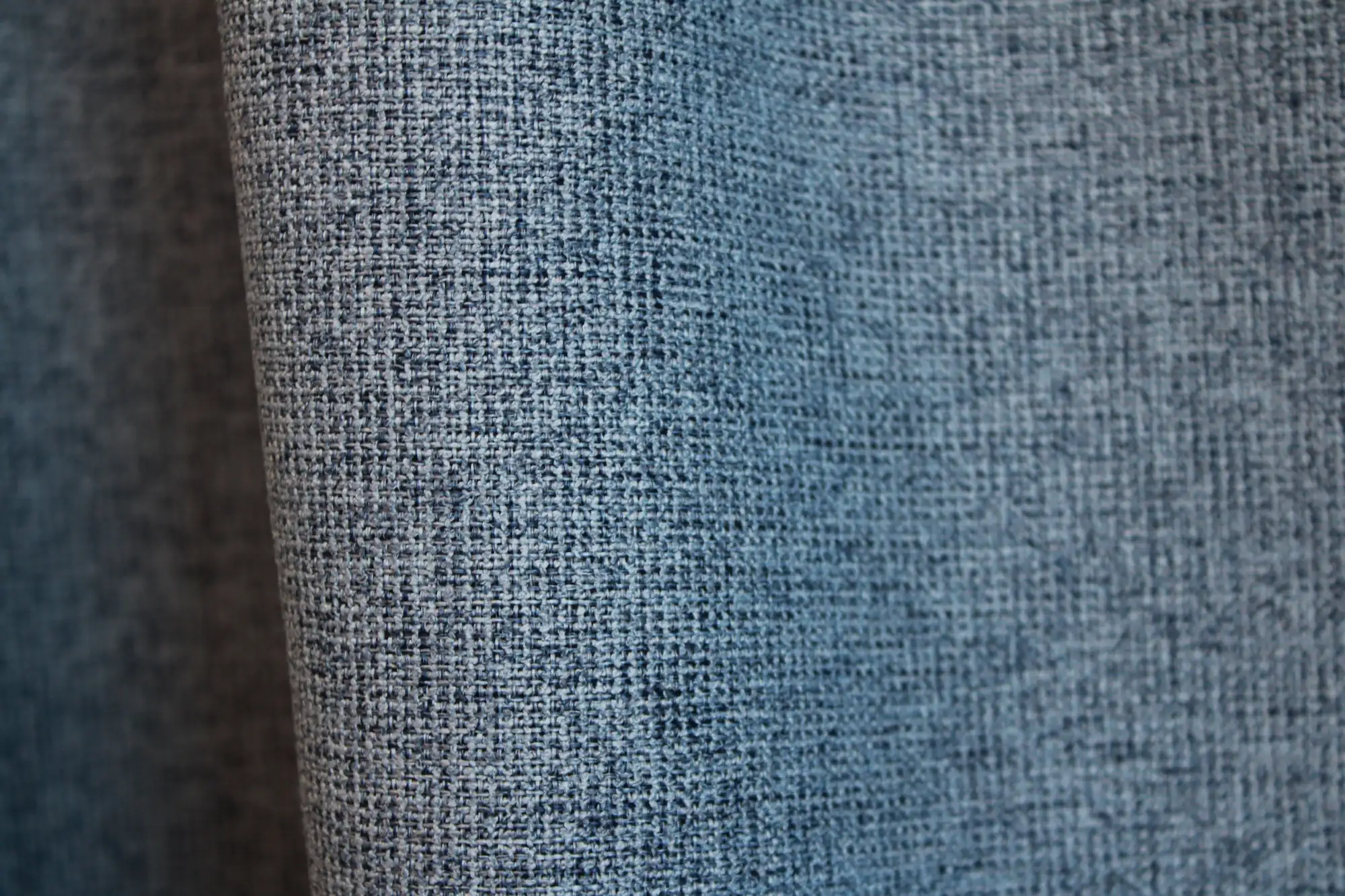 Detail van het stofpatroon van blauwe verduisterende PureShade gordijnen. De licht gemêleerde weving aan de voorzijde geeft de stof extra diepte, met een verduisterende achterkant in dezelfde blauwtint.