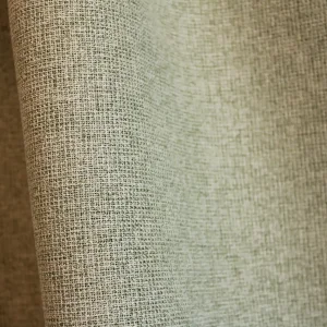 Stofpatroon van groene verduisterende PureShade gordijnen met een subtiele geweven structuur aan de voorzijde en een meekleurende verduisterende achterkant. De stof heeft een rustige, matte uitstraling en is aan beide zijden in dezelfde groentint uitgevoerd.